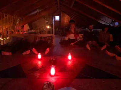 a group of people sitting in a room with red candles at Casa Cantadora in Ambasmestas