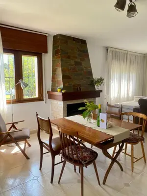 a living room with a table and a fireplace at Casa Lupe, retiro rural cerca de A Coruña in A Coruña