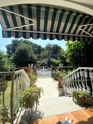 a patio with a blue and white umbrella at Maison familiale avec vue in Puente-Castrelo