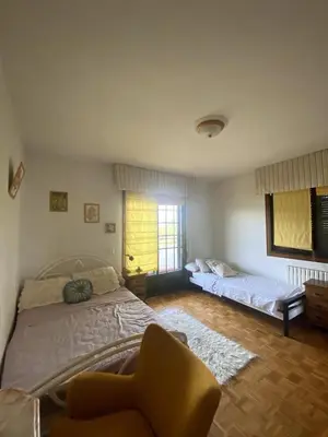 a bedroom with a bed and a chair and a window at Maison familiale avec vue in Puente-Castrelo