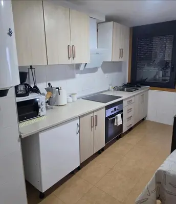 a kitchen with a sink and a stove top oven at Casa de sney in Sarria