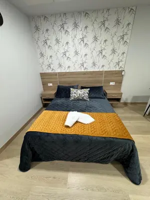 a bedroom with a bed with two towels on it at Apartamentos Turisticos Peregrin Palas in Palas de Rei
