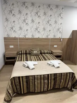 a bedroom with a bed with two towels on it at Apartamentos Turisticos Peregrin Palas in Palas de Rei