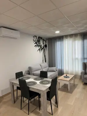 a living room with a table and a couch at Apartamentos Turisticos Peregrin Palas in Palas de Rei