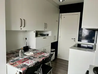a kitchen with a table with chairs and white cabinets at El Marquesado de Santiago en Milladoiro in Milladoiro