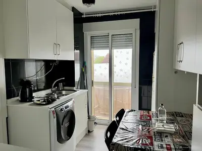 a kitchen with white cabinets and a sink and a table at El Marquesado de Santiago en Milladoiro in Milladoiro