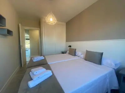 a bedroom with two beds and a chandelier at Adeline in Caldas de Reis