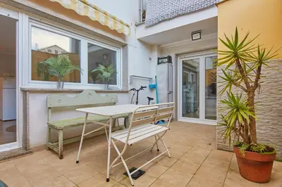 a table and bench on a patio with plants at Apartamento Porto Foz in Foz