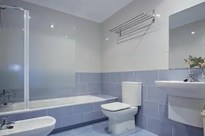 a bathroom with a toilet and a sink and a tub at Apartamento Porto Foz in Foz