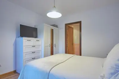 a bedroom with a bed and a tv on a dresser at Apartamento Porto Foz in Foz