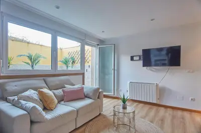 a living room with a couch and a flat screen tv at Apartamento Porto Foz in Foz