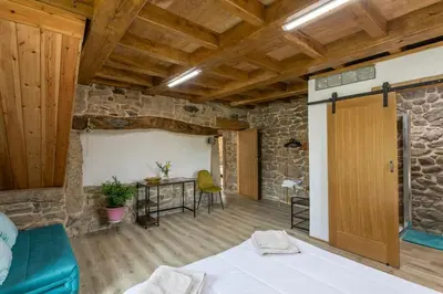 a room with a bed and a table with chairs at Casa Vacacional Retiro Rural en el Camino The Land of Eve in Friol