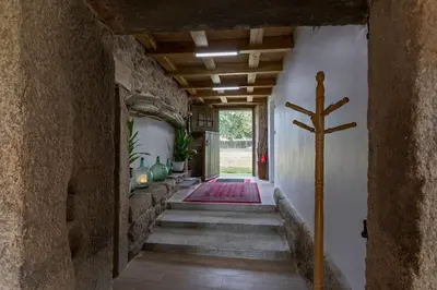 a hallway with stairs with a cross on the wall at Casa Vacacional Retiro Rural en el Camino The Land of Eve in Friol