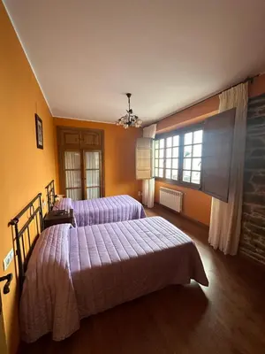 a bedroom with two beds and a window at Apartamentos Helenias in Boal