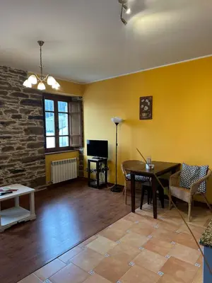 a living room with yellow walls and a table and chairs at Apartamentos Helenias in Boal