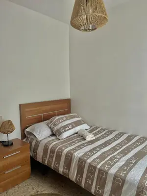 a bedroom with a bed and a night stand and a lamp at Rincón rural in Tomonde