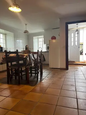 a kitchen with a table and chairs and a refrigerator at Rincón rural in Tomonde