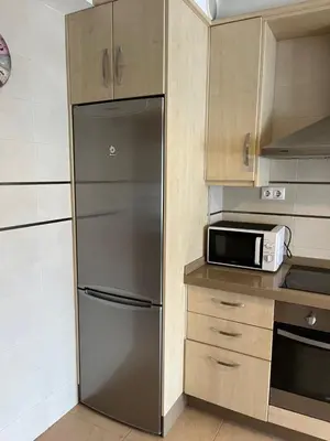 a kitchen with a stainless steel refrigerator and a microwave at A Cuarta Ronda II in Melide