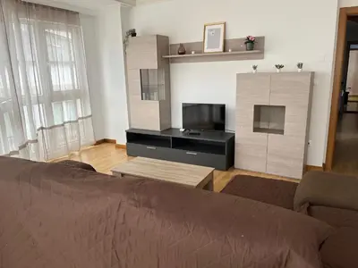 a living room with a bed and a tv at A Cuarta Ronda II in Melide