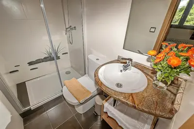 a bathroom with a sink and a shower at La Trucha del Arco Iris in El Acebo de San Miguel