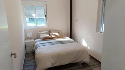 a small bedroom with a bed with a window at Tu Escapada a Coruña in Guísamo