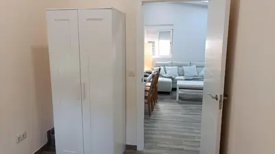 a room with white cabinets and a living room at Tu Escapada a Coruña in Guísamo