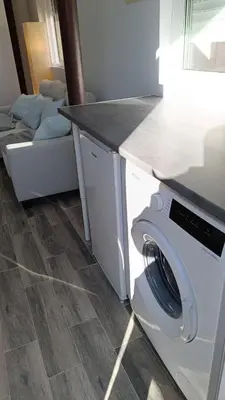 a washer and dryer in a kitchen with a couch at Tu Escapada a Coruña in Guísamo