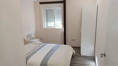 a white bedroom with a bed and a window at Tu Escapada a Coruña in Guísamo