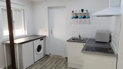 a white kitchen with a sink and a washing machine at Tu Escapada a Coruña in Guísamo