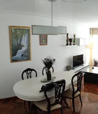 a dining room with a white table and chairs at Cruxa Apartments garaje incluido in Santiago de Compostela