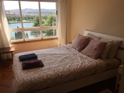 a bedroom with a bed with a large window at Apartamento luminoso con vistas a la ría in Cambre