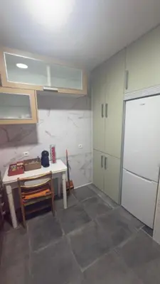 a kitchen with a table and a white refrigerator at apartamento TAHOCES 1 VUT-LE-1369 in Ponferrada