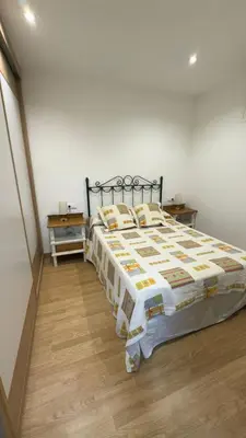 a bedroom with a large bed with yellow and white sheets at apartamento TAHOCES 1 VUT-LE-1369 in Ponferrada