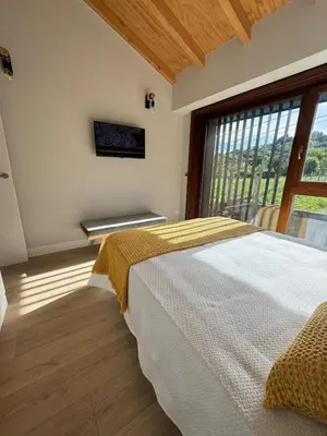 a bedroom with a large bed and a large window at Casa a Xanela Azul in Celanova