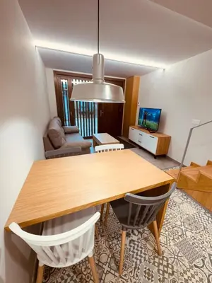 a dining room with a wooden table and chairs at Casa a Xanela Azul in Celanova