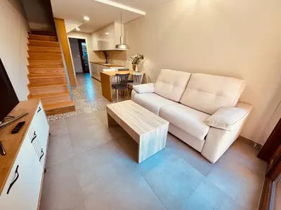 a living room with a white couch and a table at Casa a Xanela Azul in Celanova