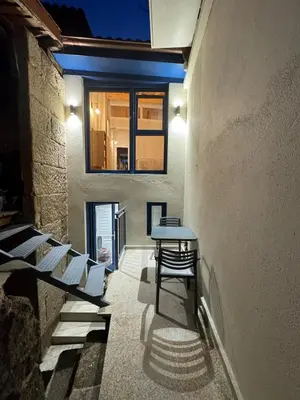 a hallway with a table and chairs in a building at Casa a Xanela Azul in Celanova