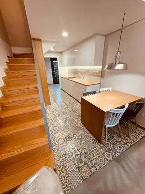 a kitchen with a wooden table and a staircase at Casa a Xanela Azul in Celanova