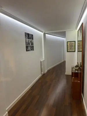 a hallway with white walls and a wooden floor at APARTAMENTO TURISTICO PLAZA DEL AYUNTAMIENTO in Ponferrada