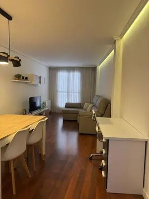 a living room with a table and a couch at APARTAMENTO TURISTICO PLAZA DEL AYUNTAMIENTO in Ponferrada