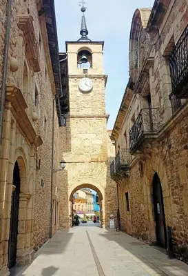 a building with a clock tower in a street at APARTAMENTO TURISTICO PLAZA DEL AYUNTAMIENTO in Ponferrada