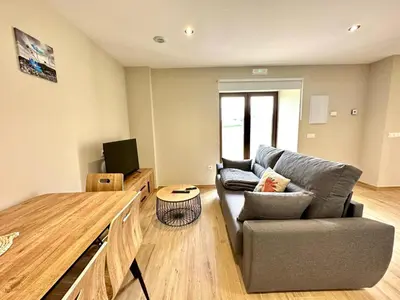 a living room with a couch and a television at Apartamentos Casa Courego in Vegadeo