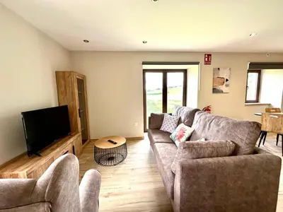 a living room with a couch and a flat screen tv at Apartamentos Casa Courego in Vegadeo