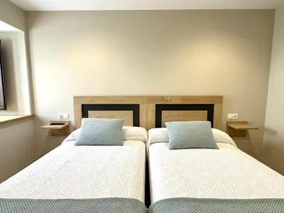 two beds in a room with two pillows at Apartamentos Casa Courego in Vegadeo