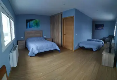 a bedroom with two beds and blue walls at Pensión Palomos in San Xoán de Río