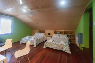 a bedroom with two beds and a ceiling at acasadeblanco in Teo