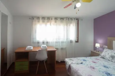 a bedroom with a desk and a bed and a window at acasadeblanco in Teo