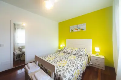 a bedroom with a bed and a yellow wall at acasadeblanco in Teo