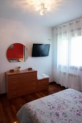a bedroom with a bed and a mirror and a dresser at acasadeblanco in Teo