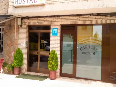 a front door of a restaurant with a sign on it at Hostal Caracas in Lalín